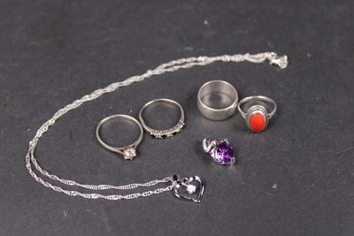 un collier, une bague, un bracelet et d'autres bijoux posés sur une table