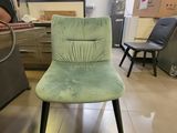 a green chair sitting in a room with other chairs