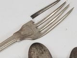 three spoons and a fork sitting on a table