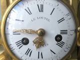 a gold clock with roman numerals on the face