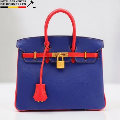 un sac à main bleu et rouge muni d'un cadenas sur la poignée