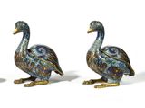 two blue and gold ducks sitting next to each other on a white surface