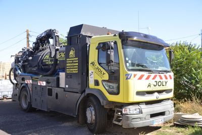 un camion jaune et noir garé sur le bord de la route