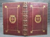 un vieux livre à la couverture rouge ornée de motifs dorés
