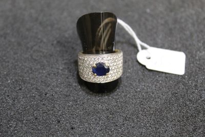 an image of a ring with a blue sapphire and diamonds on it