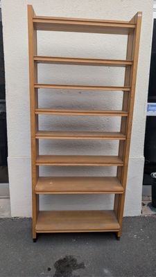 a tall wooden shelf with a lot of shelves on it