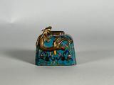 une petite clochette bleue et dorée ornée d'un dragon