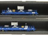 deux wagons bleus dans une boîte posée sur une surface blanche