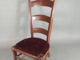 a wooden chair with a red seat on a white background
