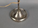 a silver lamp that has a cord on top of it
