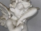 a statue of an angel holding a fan in his hand