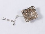 an image of a silver broochle on a white surface