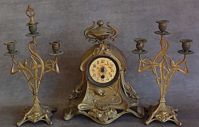 trois bougies et une horloge posées sur une table