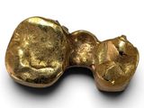 a gold object on a white surface with a white background