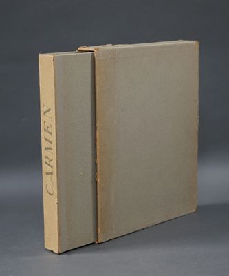 un livre ouvert posé sur une table, devant un fond gris