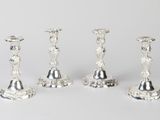trois bougeoirs en argent sont posés les uns à côté des autres sur une table