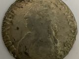 an old silver coin sitting on top of a white surface
