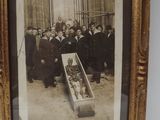 an old photo of a group of people standing around a coffin