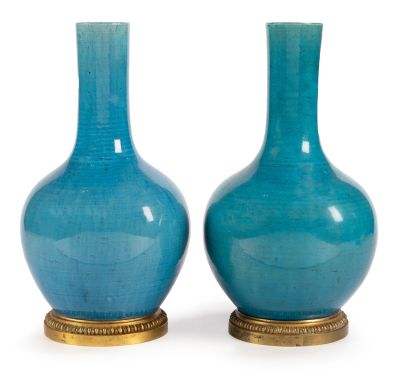 pair of blue glass vases with gold bases on a white background