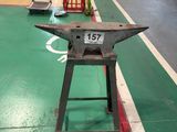 a metal anvil on a green floor in a warehouse