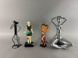 three figurines of a woman, a man and a cat on a table