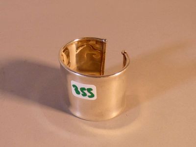une bague en argent sur laquelle est collé un autocollant vert