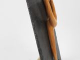 wooden figurine of a woman on a black slate board