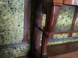 a wooden bench in a room with a wallpapered wall