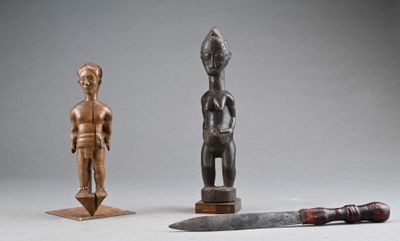 two wooden figurines and a knife on a table