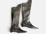 two pairs of black boots with zippers on them on a white surface
