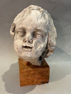 sculpture of a child ' s head on a wooden block