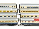three silver and red train cars sitting next to each other on a white surface