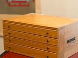a small wooden box sitting on top of a red table