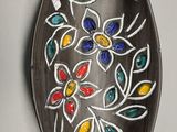 une assiette décorative accrochée au mur, ornée d'un motif floral