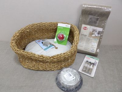 un panier en osier contenant un panier pour chat et d'autres objets posés sur la table