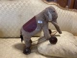 a stuffed elephant that is sitting on a pillow on a couch