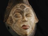 une image représentant un masque en bois sur fond noir