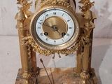 une horloge en or surmontée d'un aigle