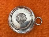 a silver object on an orange cloth with a metal ring