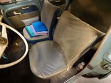 an old car with a seat up and a book on the dashboard