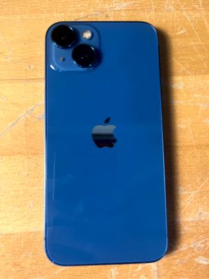Un iPhone d'Apple est posé sur une table en bois, dans un étui bleu.