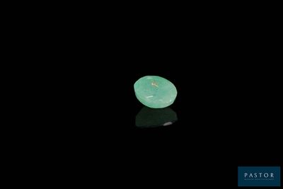 a close up of a piece of green jade on a black surface