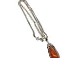 a silver necklace with a tear shaped pendant on a chain