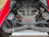 a red car with a large engine in the back of it