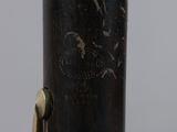 an image of a close up of a flute with a wooden stick in the foreground