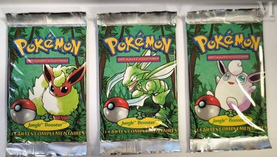 three packs of pokemon trading cards sitting on top of a shelf
