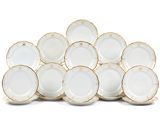 une pile d'assiettes blanches et dorées posées sur une surface blanche
