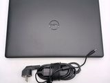dell laptop computer with power cord and charger sitting on a white surface