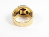 a close up of a gold ring with a diamond in the center