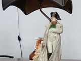 une statue représentant un homme tenant un parapluie, posée sur un bureau